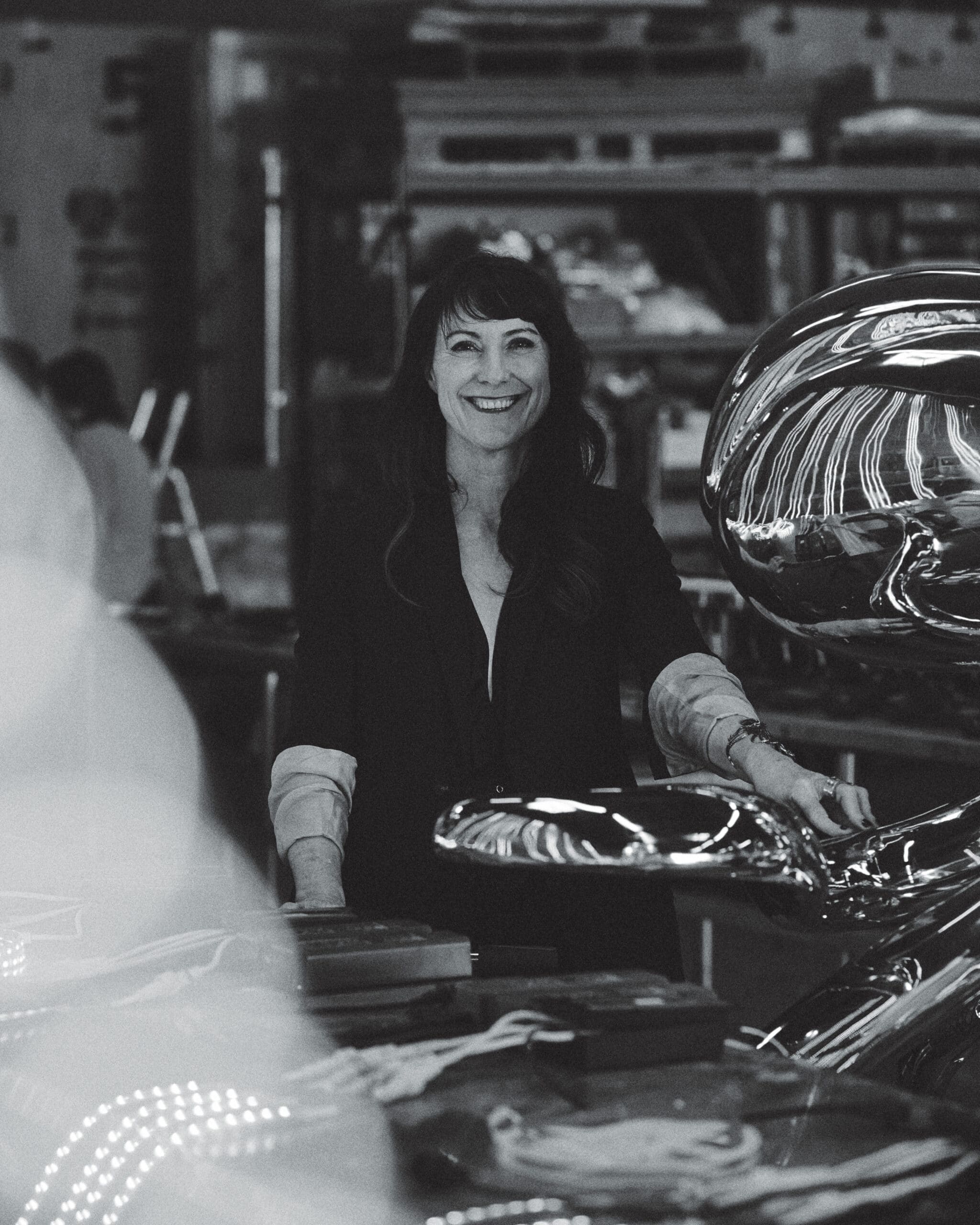 A black and white portrait of Jen Lewin in her art studio